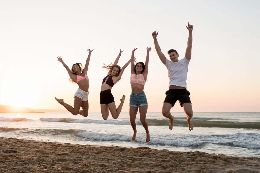 group of friends jumping on the beach