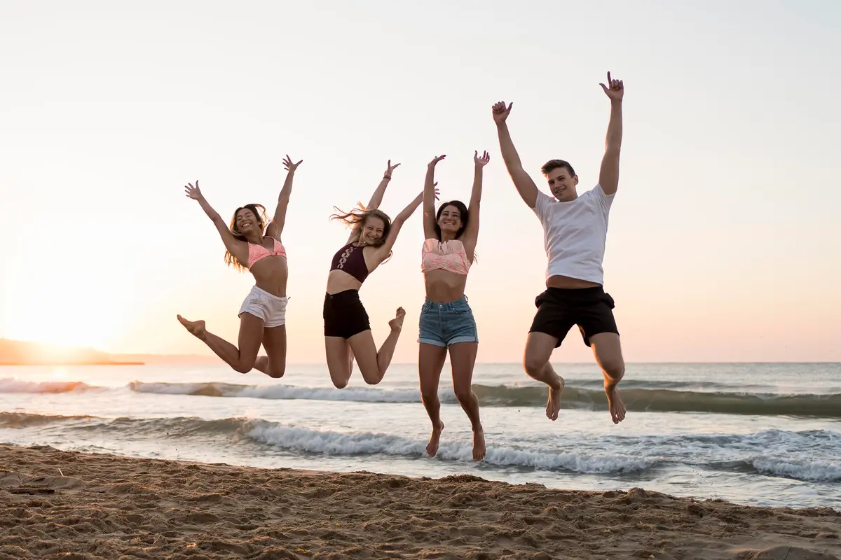 group of friends jumping on the beach