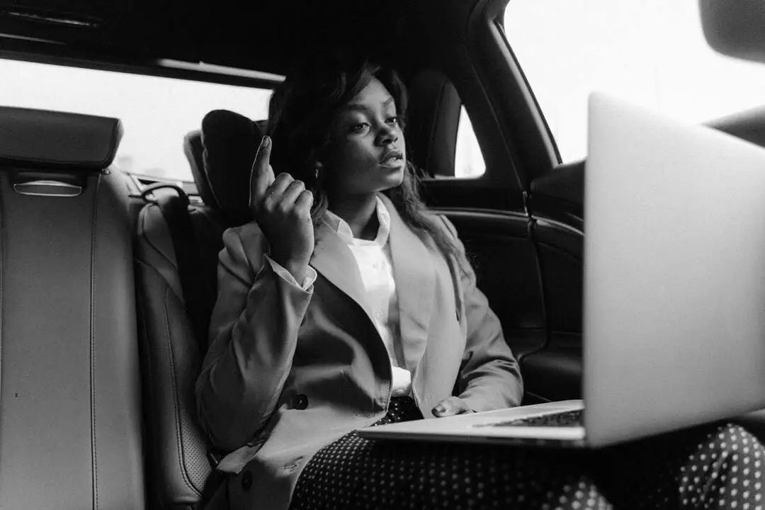 business women in a car on her laptop