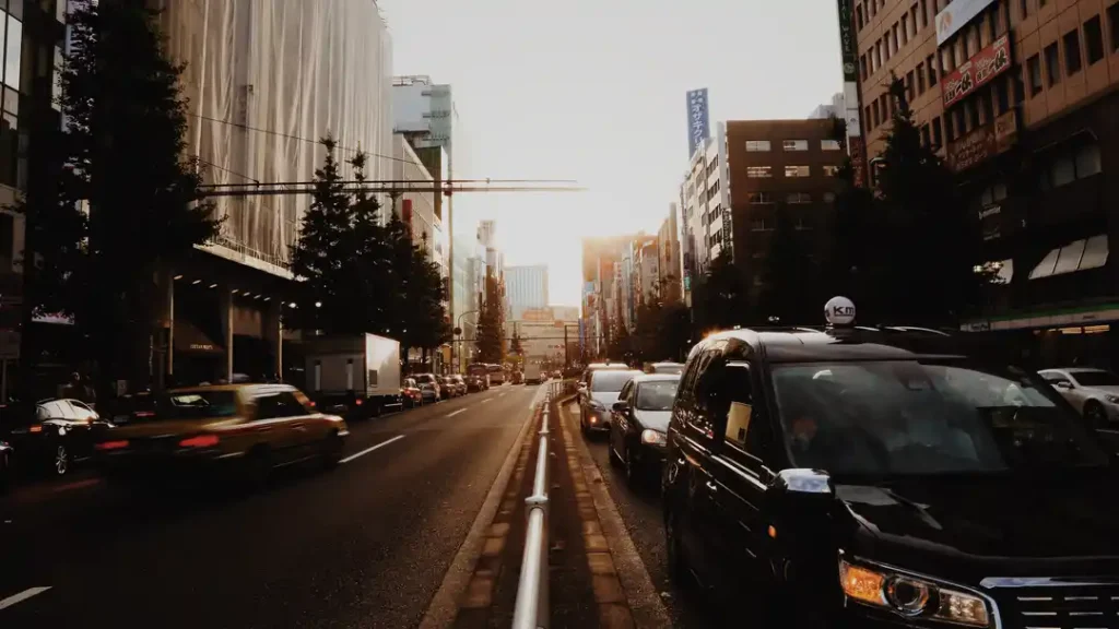 traffic road amidst buildings city against sky