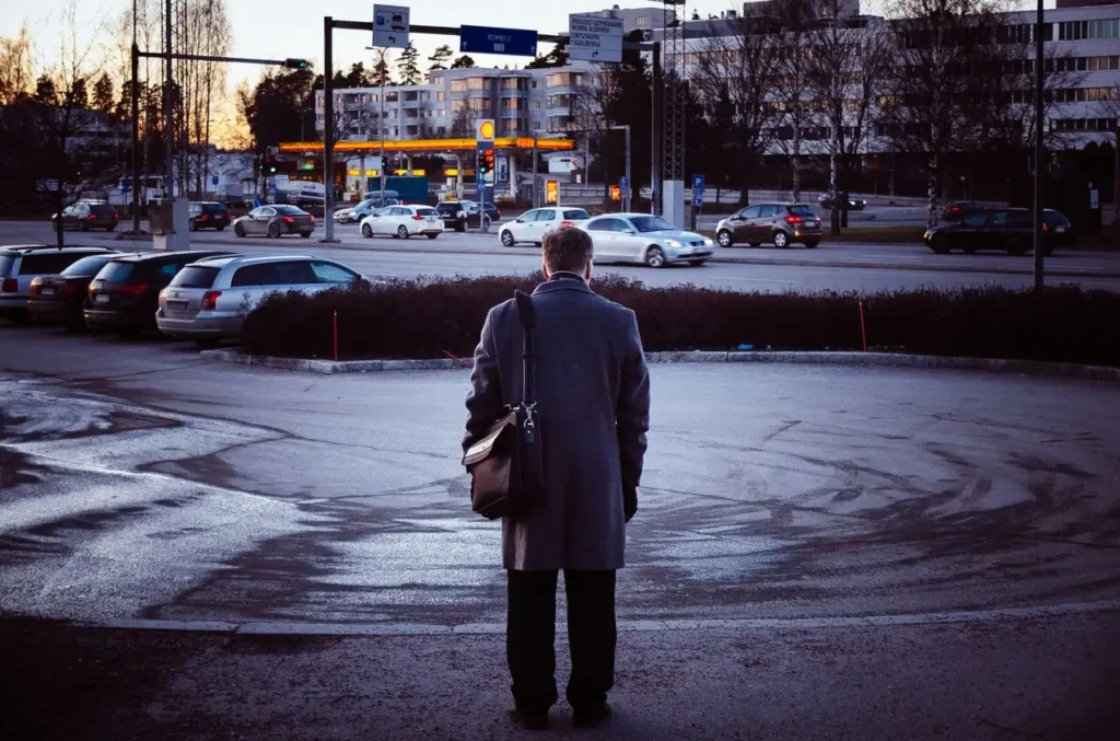 man standing on sidewalk waiting
