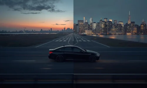 Aerial dusk view of a highway approach road with a black luxury sedan heading toward Manhattan with airport infrastructure visible on either side
